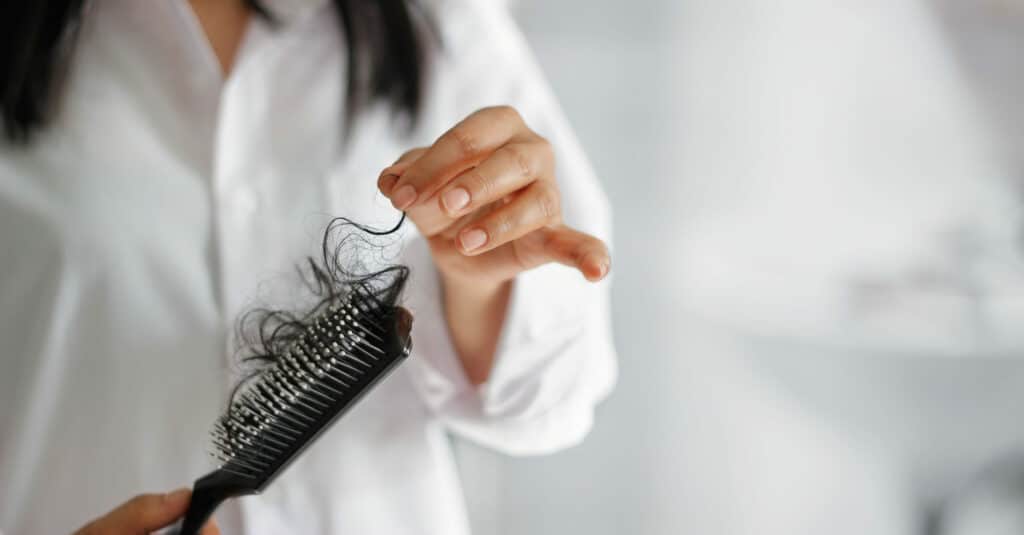 Woman,Losing,Hair,On,Hairbrush,In,Hand,Soft,Focus